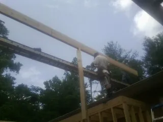 Carpenter setting a ridge beam over a new addition frame — Ice Dam Removal by Roofing Brothers in Mount Olive