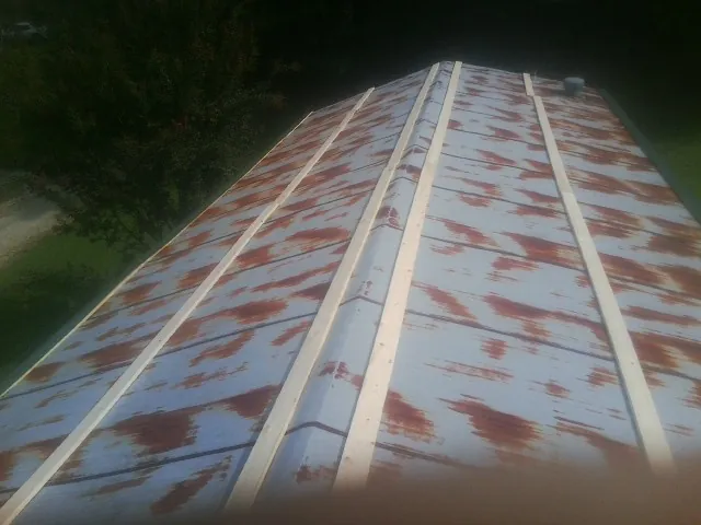 Rusted metal roof panels with new wood purlins before replacement — Storm Damage Roof Repair in Mount Olive by Roofing Brothers