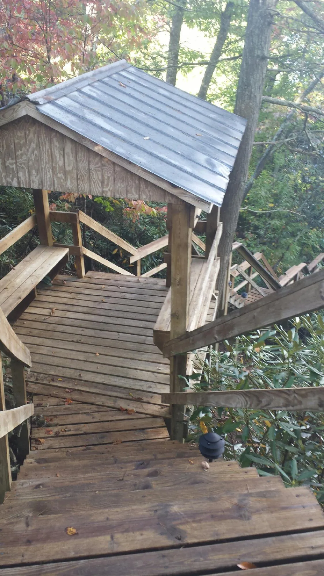 Metal roofed shelter over wooden steps on a wooded walkway — Skylight Repair & Installation work by our crew in Mount Olive